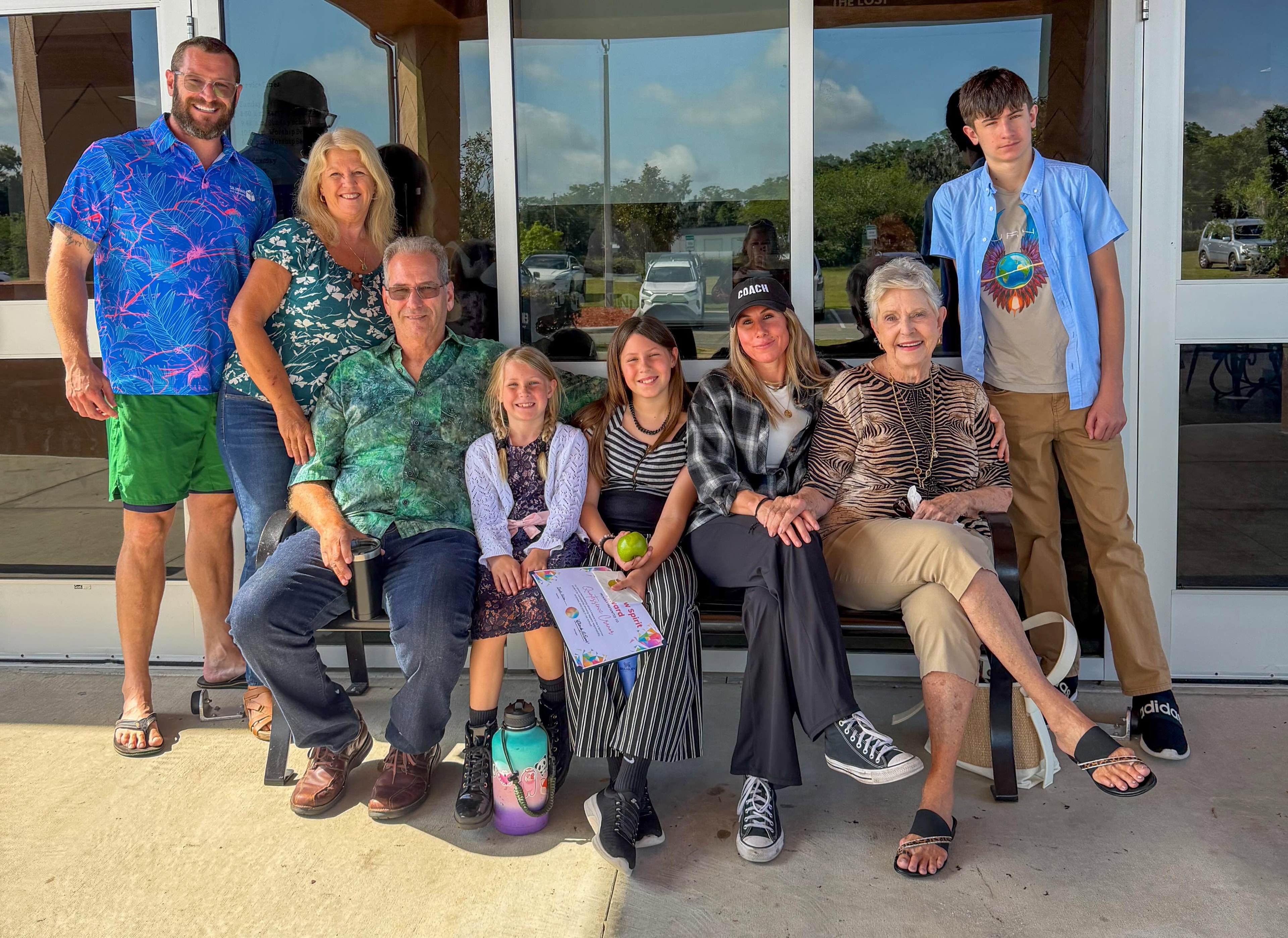 Coach with family members outside a building
